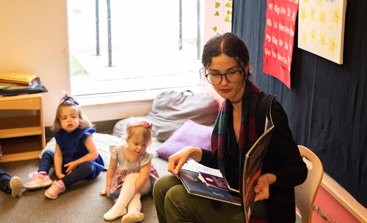 Teacher shows young students a picture book