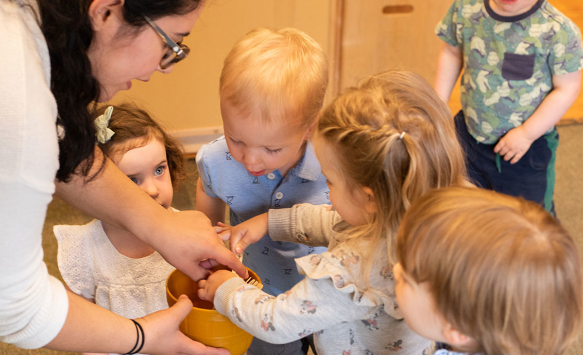 Teacher showing toddlers how to share