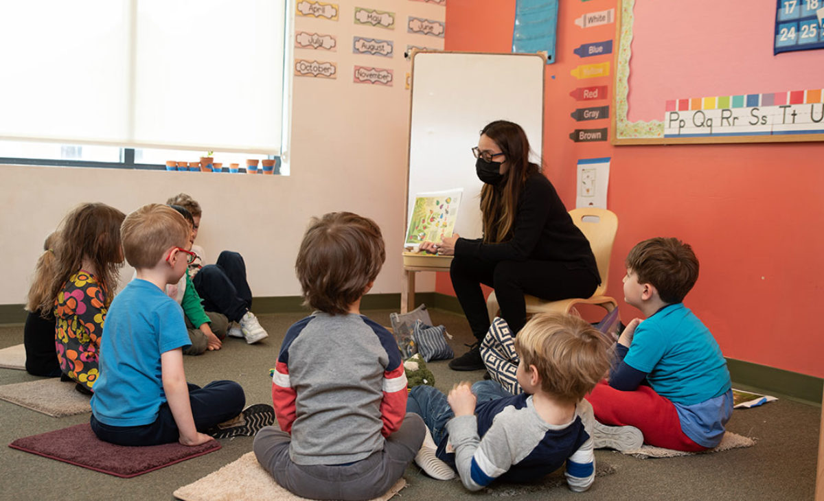 Teacher reads a picture book to a group of young students