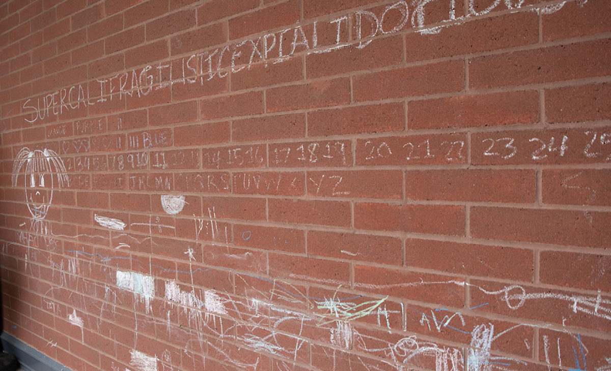 Large brick wall with chalk drawings